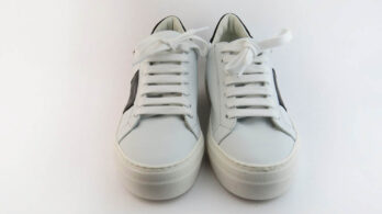 Sneakers basse colore bianco con banda laterale in vitello nero impreziosite da borchiette