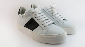 Sneakers basse colore bianco con banda laterale in vitello nero impreziosite da borchiette